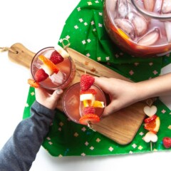 2 kids with glasses of Christmas punch.