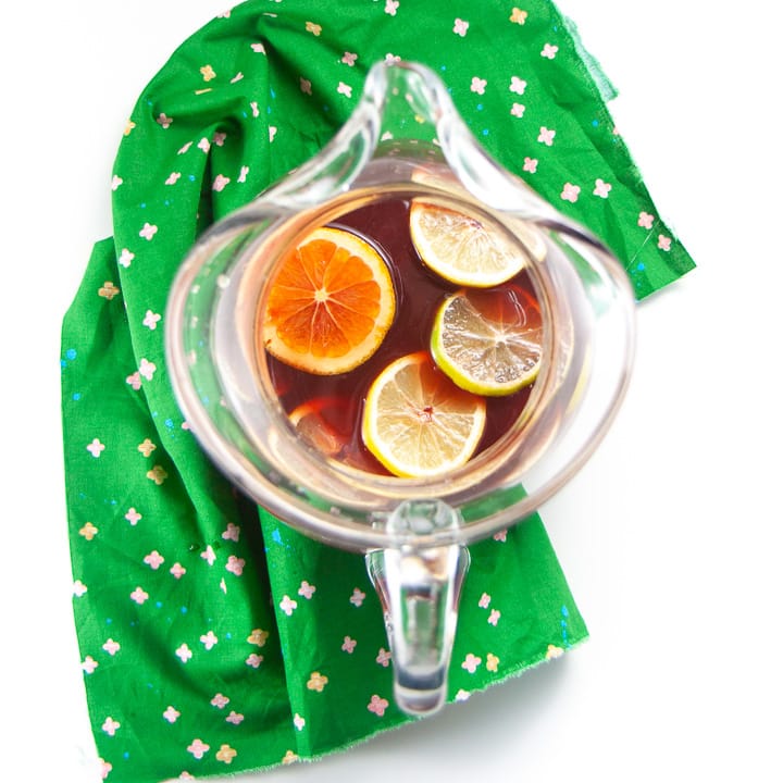 clear pitcher filled with Christmas punch and slices of fruit.