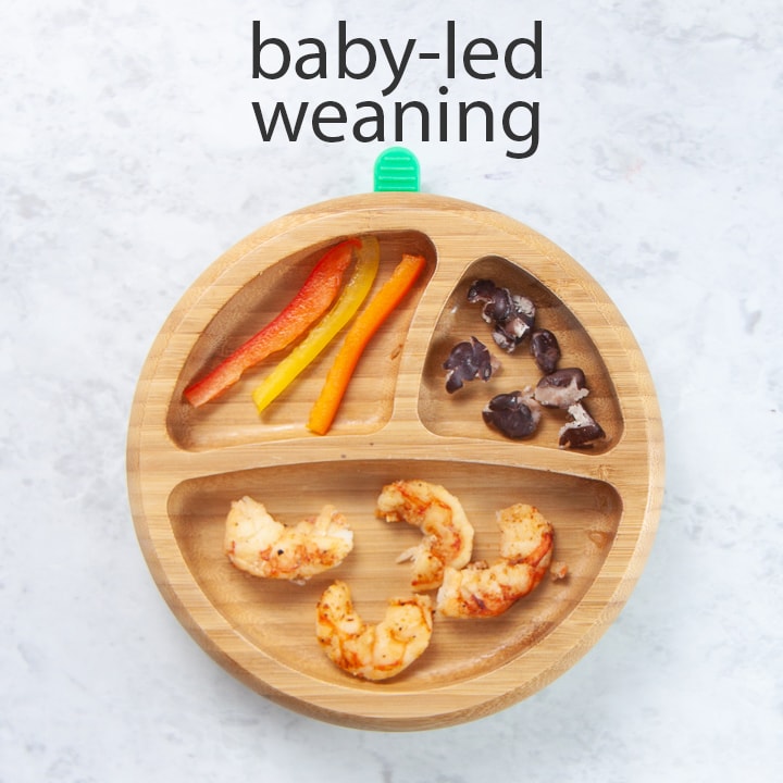wooden plate filled with shrimp tacos for baby led weaning.