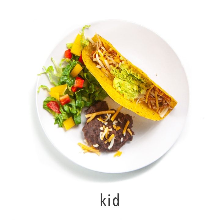 A kids plate full of tacos and sides.