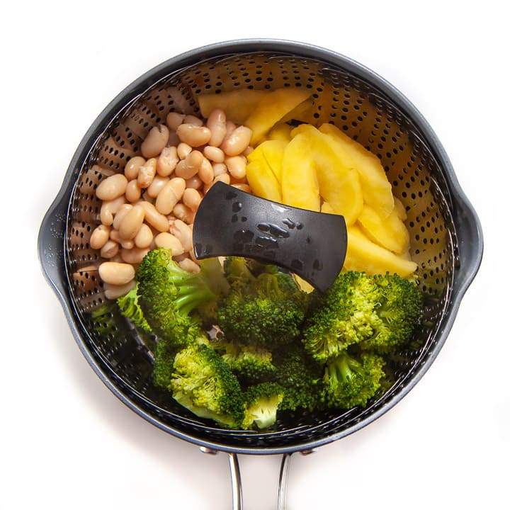 steamer pot with full meal for baby - broccoli, apple and white beans.