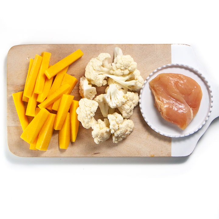 spread on cutting board of what's for baby's dinner - chicken, cauliflower and squash.