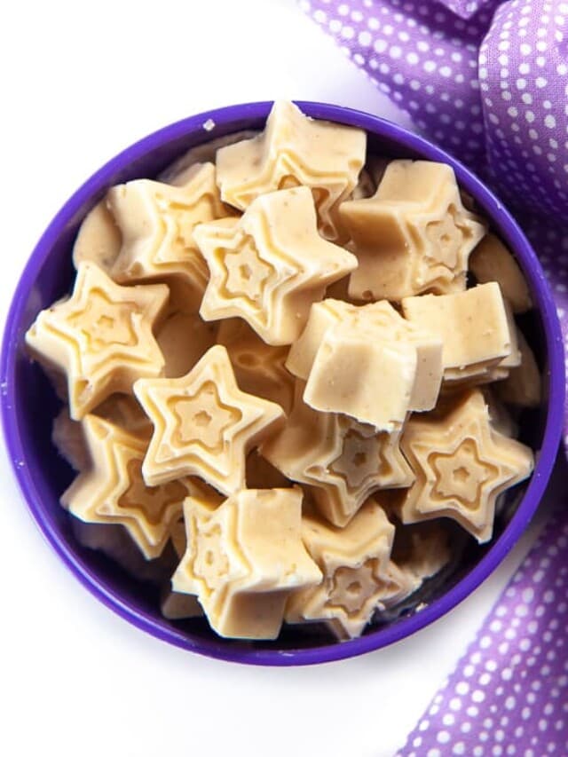 purple baby bowl with star baby melts inside with a purple napkin sitting on a white kitchen counter. 