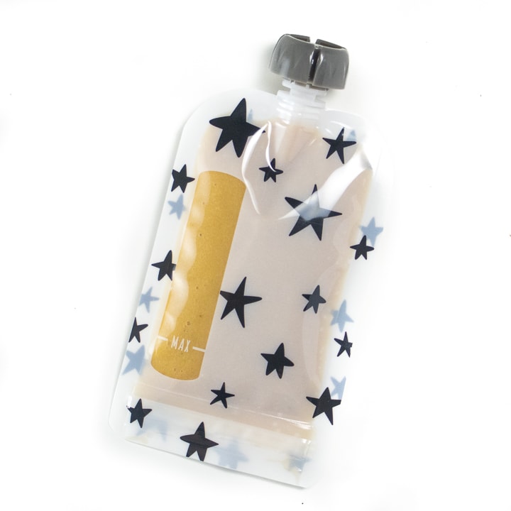 Reusable baby food pouch with banana and peach puree inside.