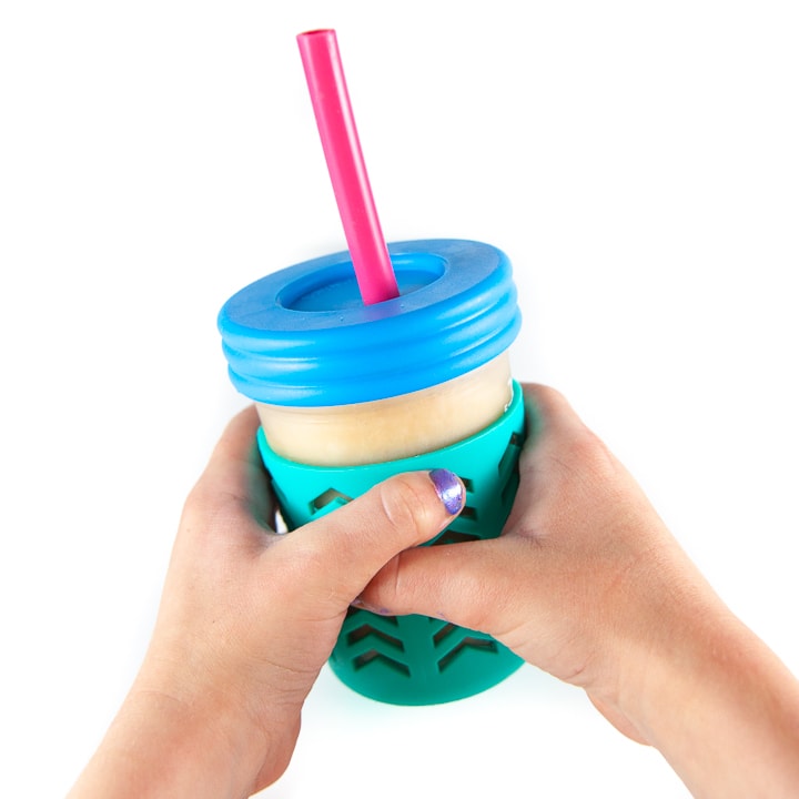 Kids hands holding up smoothie cup.