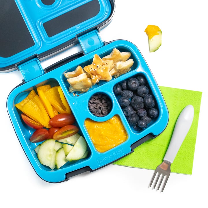 Bento box filled with a veggie loaded hummus with other healthy ingredients for toddlers and kids.