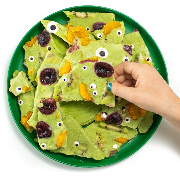 Kids hands reaching to get a piece of monster bark for halloween.