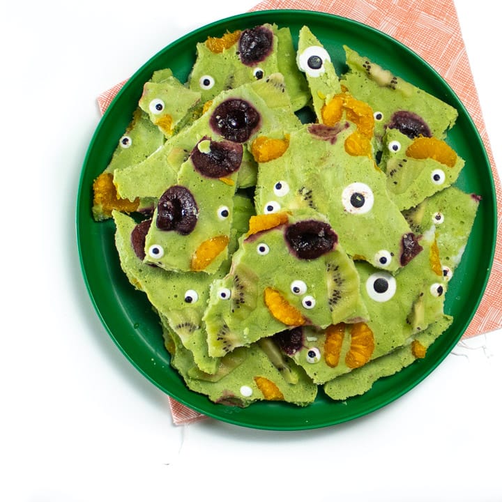 Plate of green monster frozen yogurt bark ready for kids to eat it for halloween.