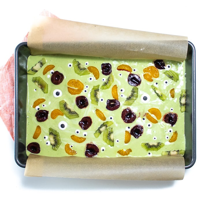 baking sheet of frozen yogurt bark with toppings ready for the freezer.