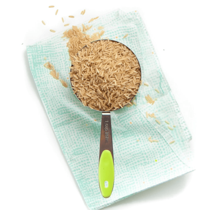 teal napkin resting on my kitchen counter, with a measuring cup full of brown rice.