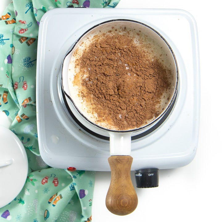 A small saucepan filled with ingredients for homemade hot chocolate.