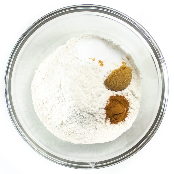 Flour, baking powder, cinnamon and brown sugar ready to get mixed together in a big bowl.