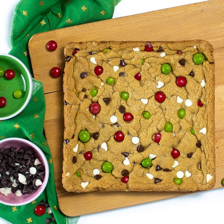 Cookie bars sitting on a cutting board getting ready to cut.