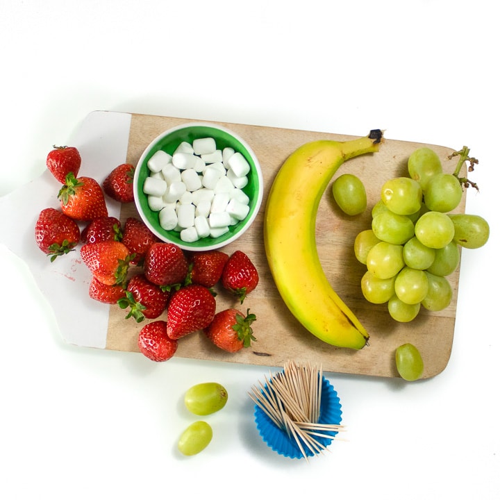 Cutting board with ingredients for grinch kabobs.
