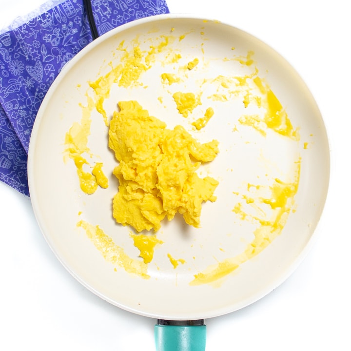 While pan with cooked scrambled eggs in it.