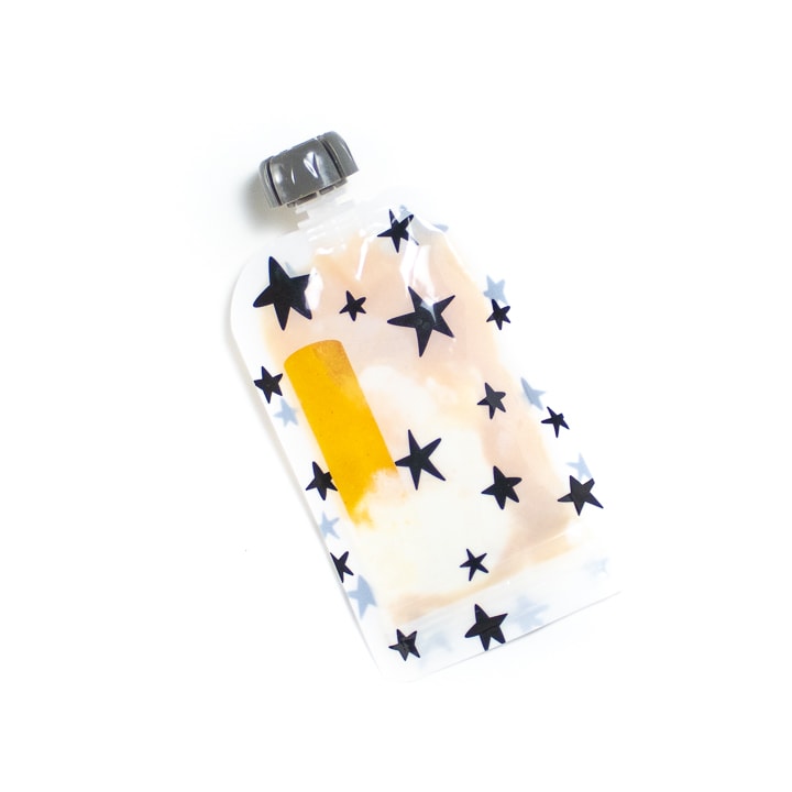 Reusable pouch full of mango puree for baby.
