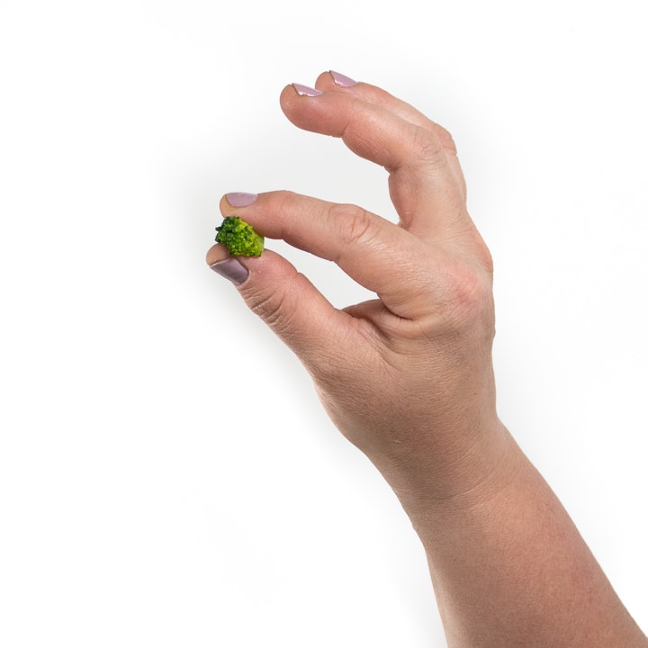 hand using a pincer grasp to pick up broccoli.