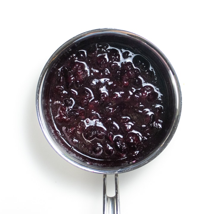 Saucepan full of simmered blueberries.