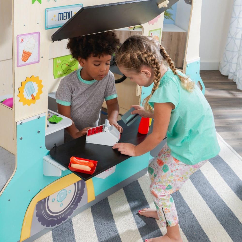 Two kids playing in a wooden food truck