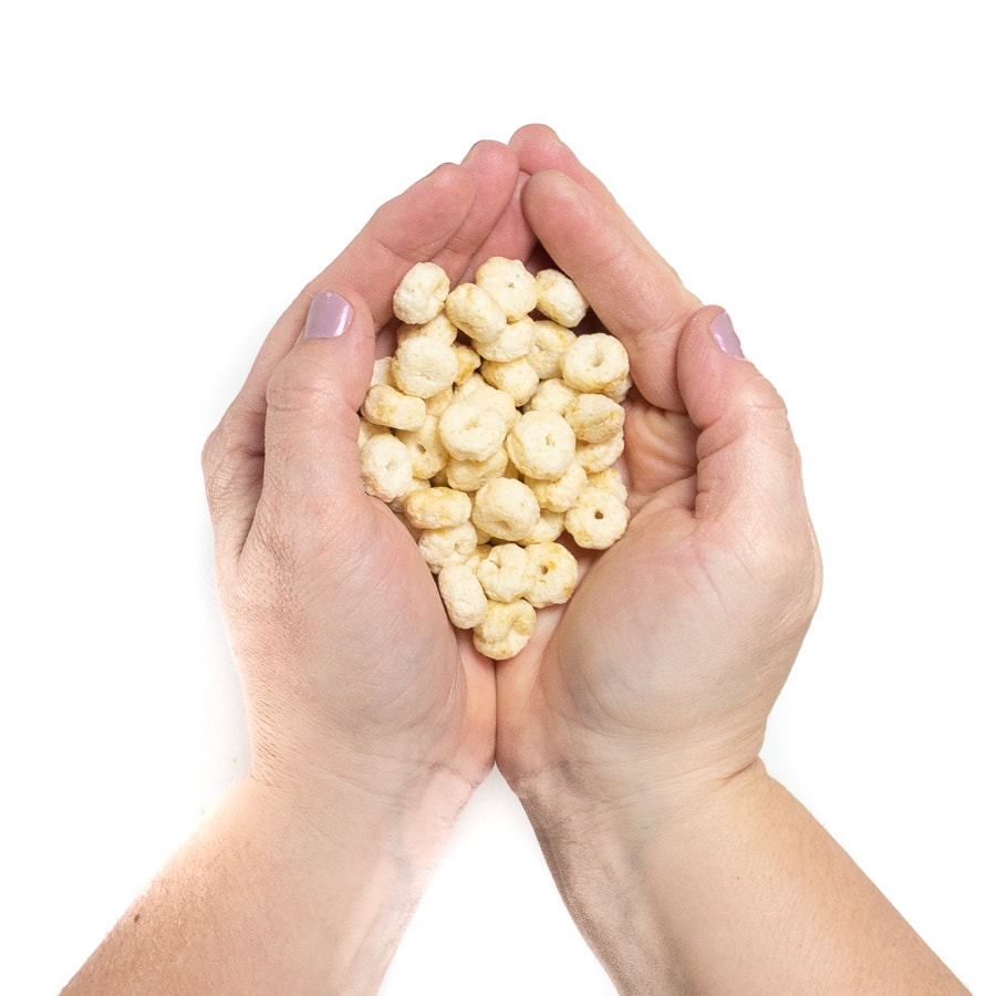 Hands holding a handful of circle puffs.
