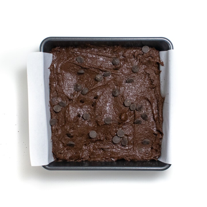 And uncooked tray of brownies ready to be baked with chocolate chips on top.
