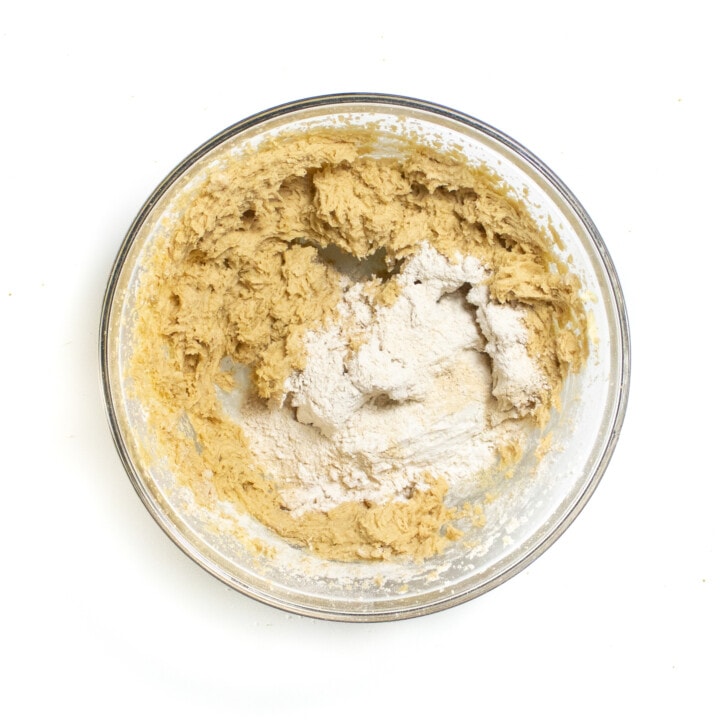 A mixing bowl with whipped butter sugar and flour on top.
