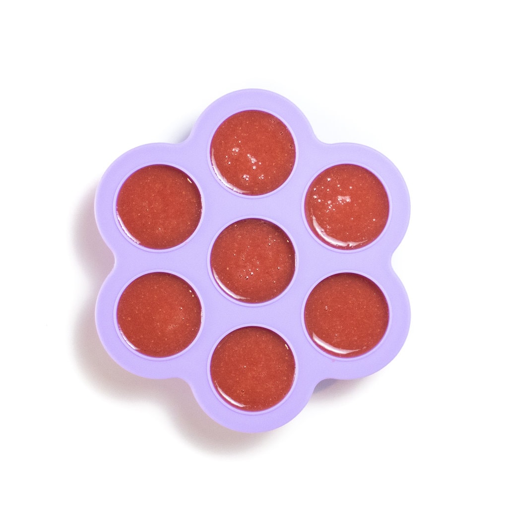 Purple popsicle tray filled with watermelon popsicle filling.