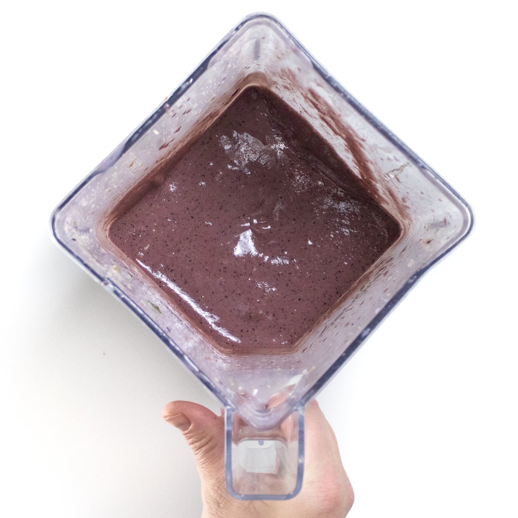 A hand holding a blender full of a smoothie for pregnancy.