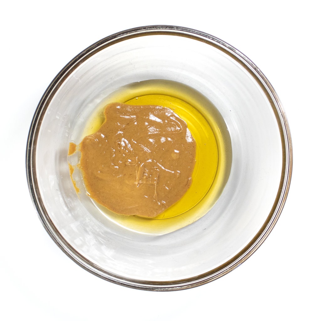 A glass bowl full of peanut butter and agave nectar.