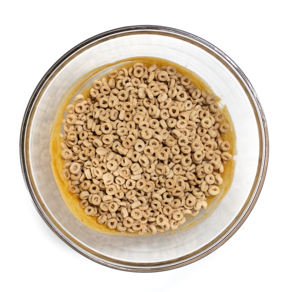 Glass bowl full of cereal, peanut butter and agave nectar.