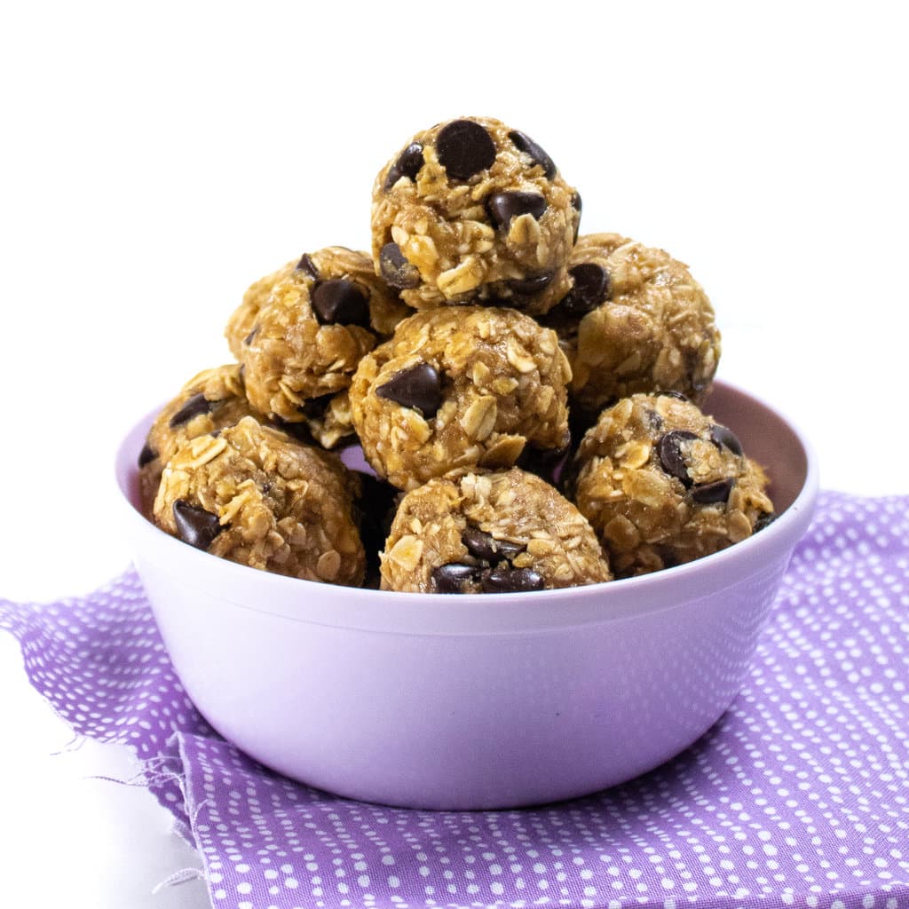 a side angle view of a purple bowl filled with ground energy bites for nursing m