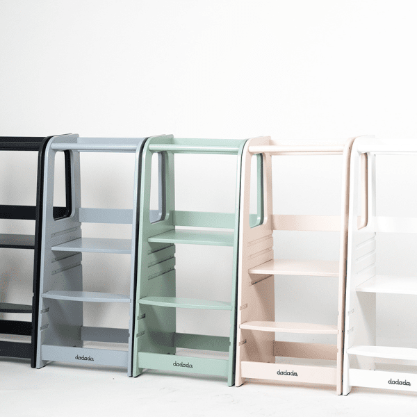 a line of neutral color toddler learning towers against a white background.