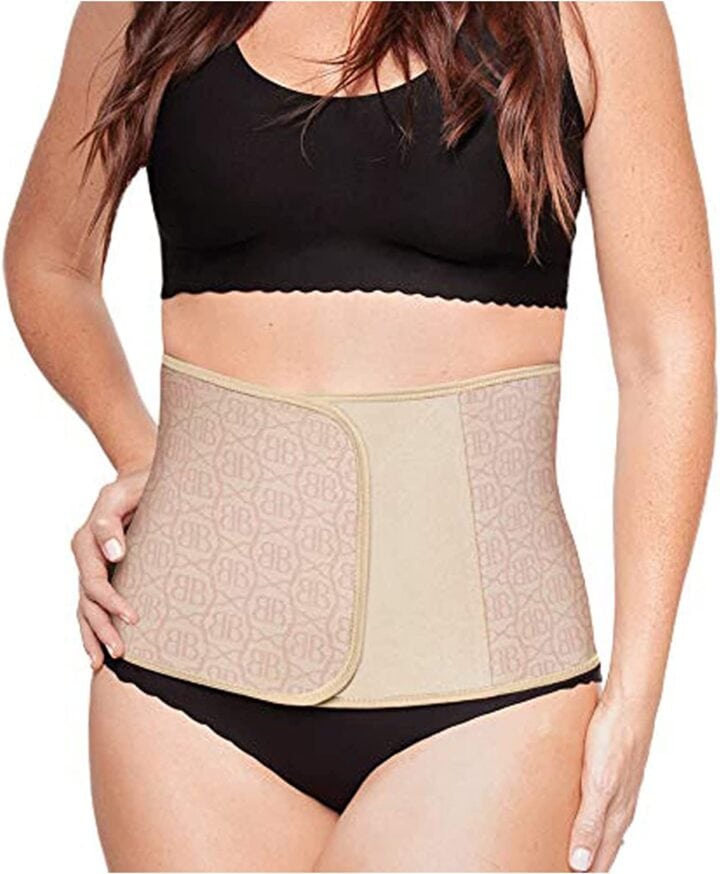 woman with brown hair in black underware with a belly band around her waist.