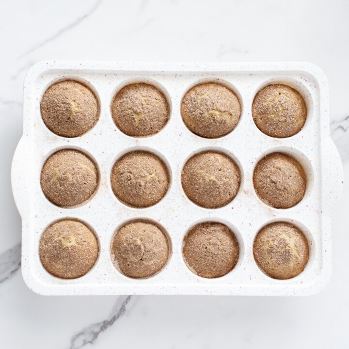 A white muffin tray full of cooked muffins.
