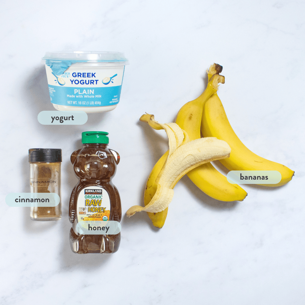 Ingredients for banana popsicles spread on a white marble counter.