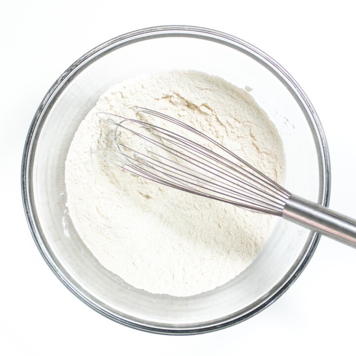 Clear mixing bowl with Ryan gradients for muffins against a white countertop.