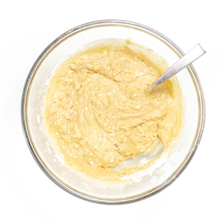 Clear bowl sitting on the white counter with muffin batter mix together.