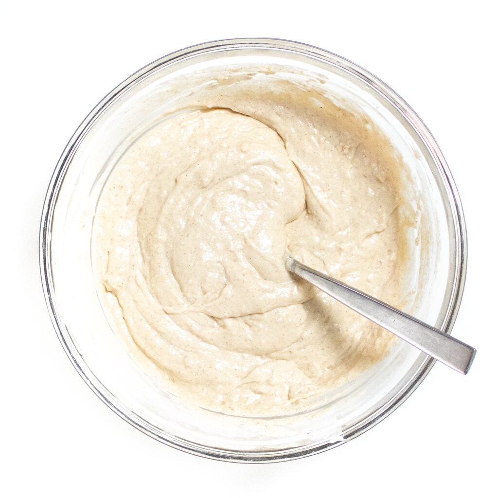 Mixed batter in a clear glass bowl for pancakes.