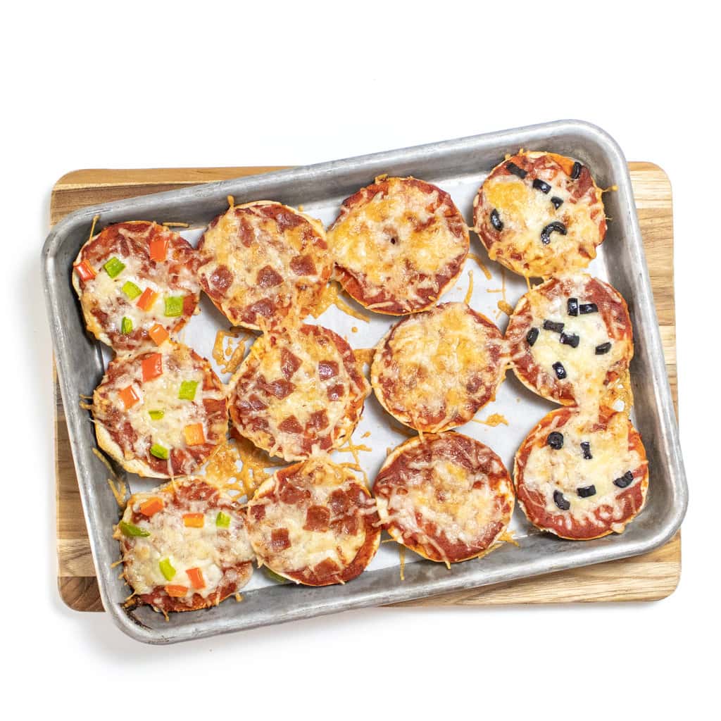 Cooked mini bagel bites on a baking sheet.