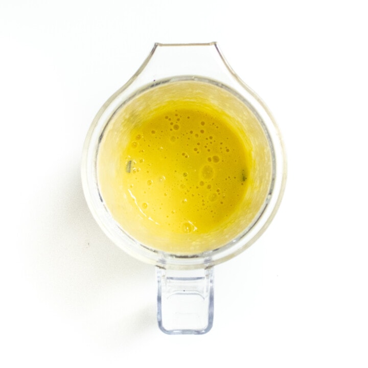 Pureed corn in a clear blender on a white counter.