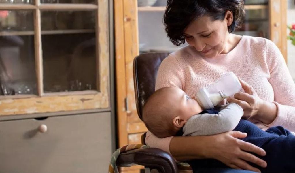Older woman feeding a baby with Philips baby bottle.
