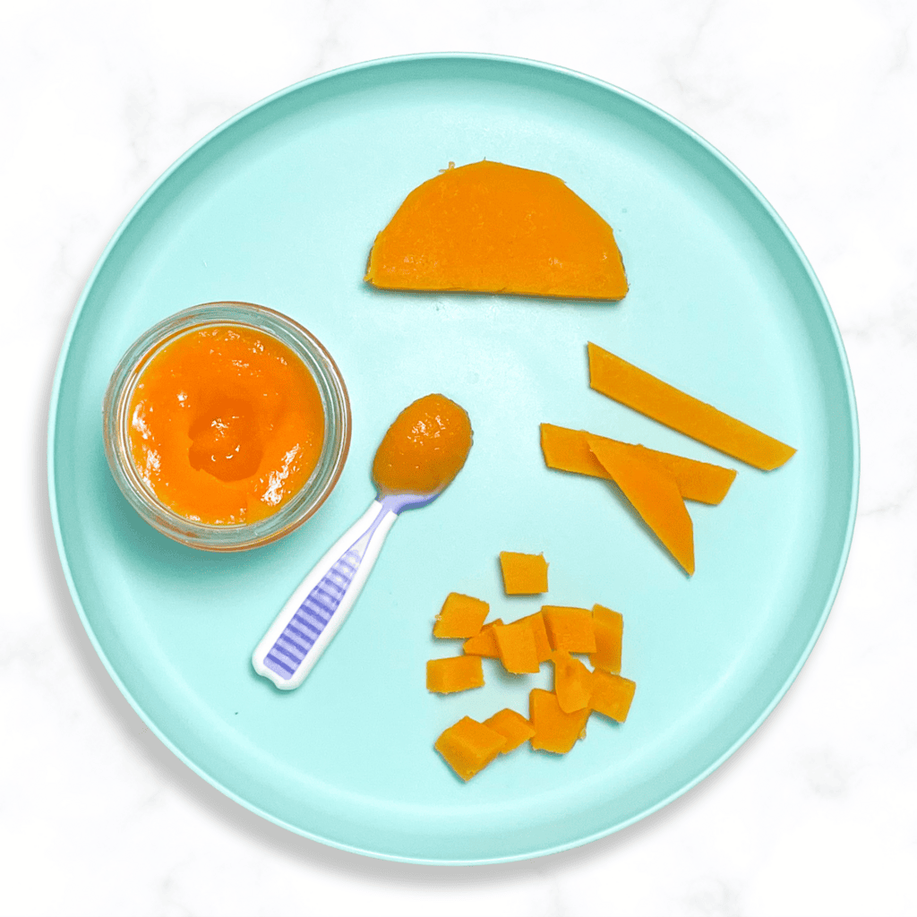 Teal baby plate wit different ways to serve butternut squash to your baby. The plate is sitting on a white marble counter in my kitchen. 