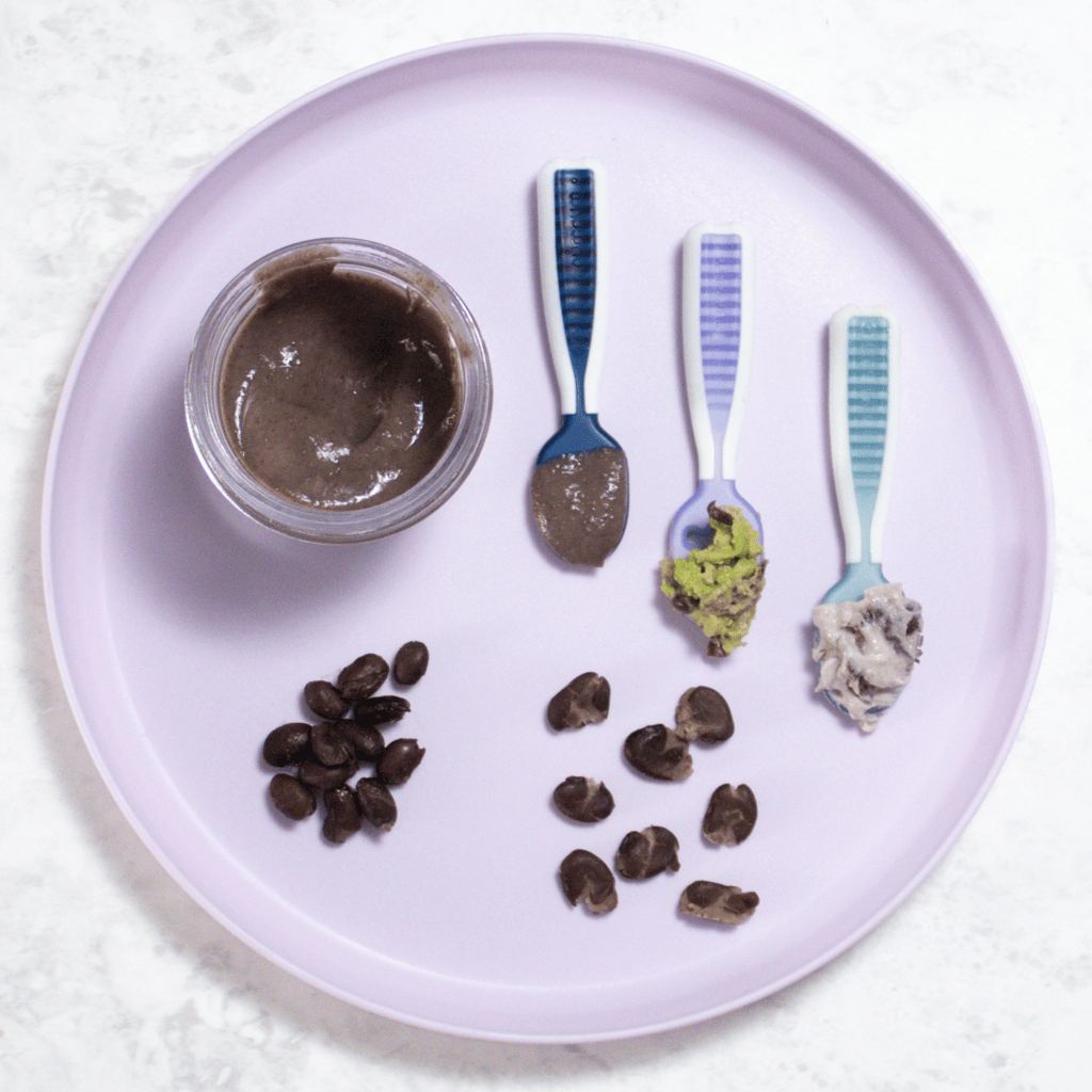 Purple baby plate with self-feeding spoons showing different ways to serve black beans to baby.