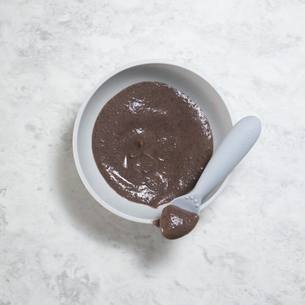 Gray baby bowl full of black bean puree for baby in it.