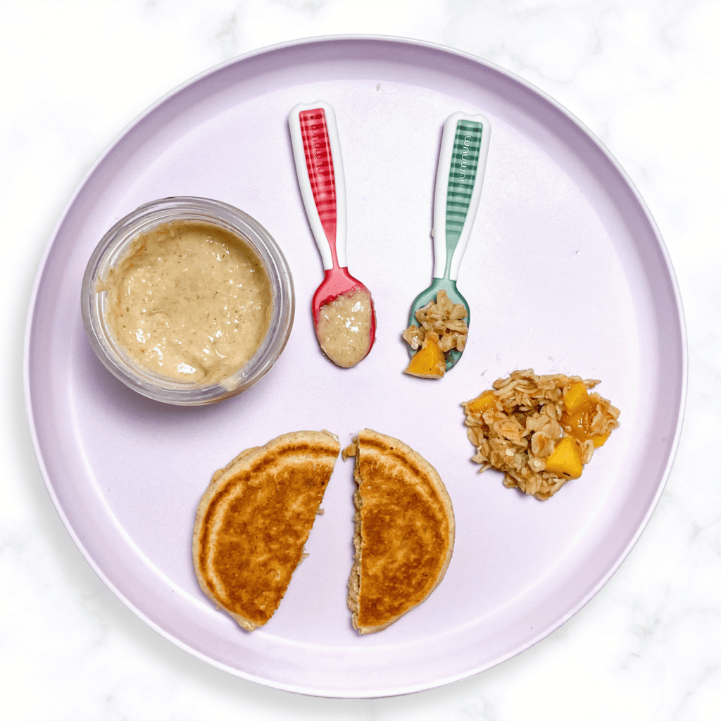 Purple baby plate on a white marble kitchen counter showing how to serve oats to your baby. 