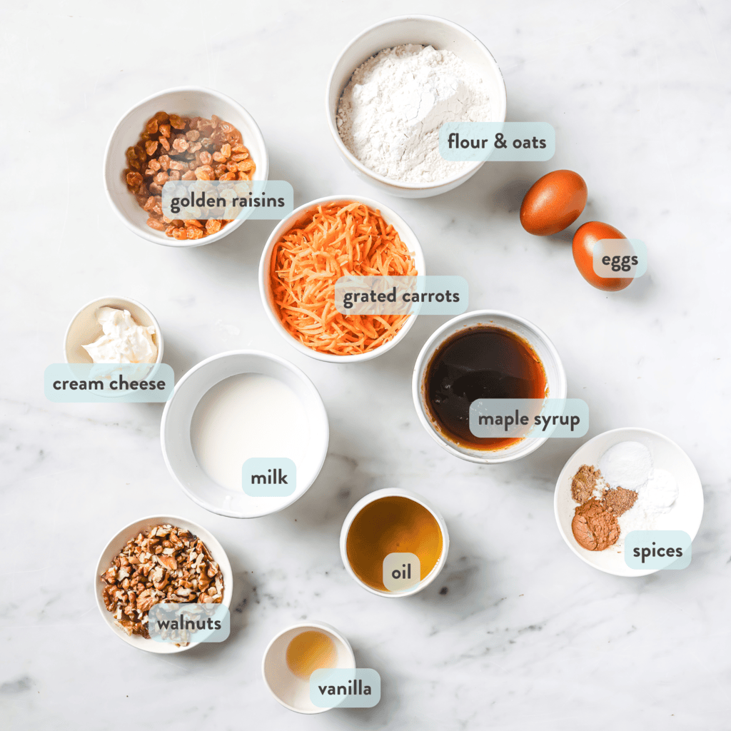 Ingredients spread out on a white marble kitchen counter for carrot muffins.