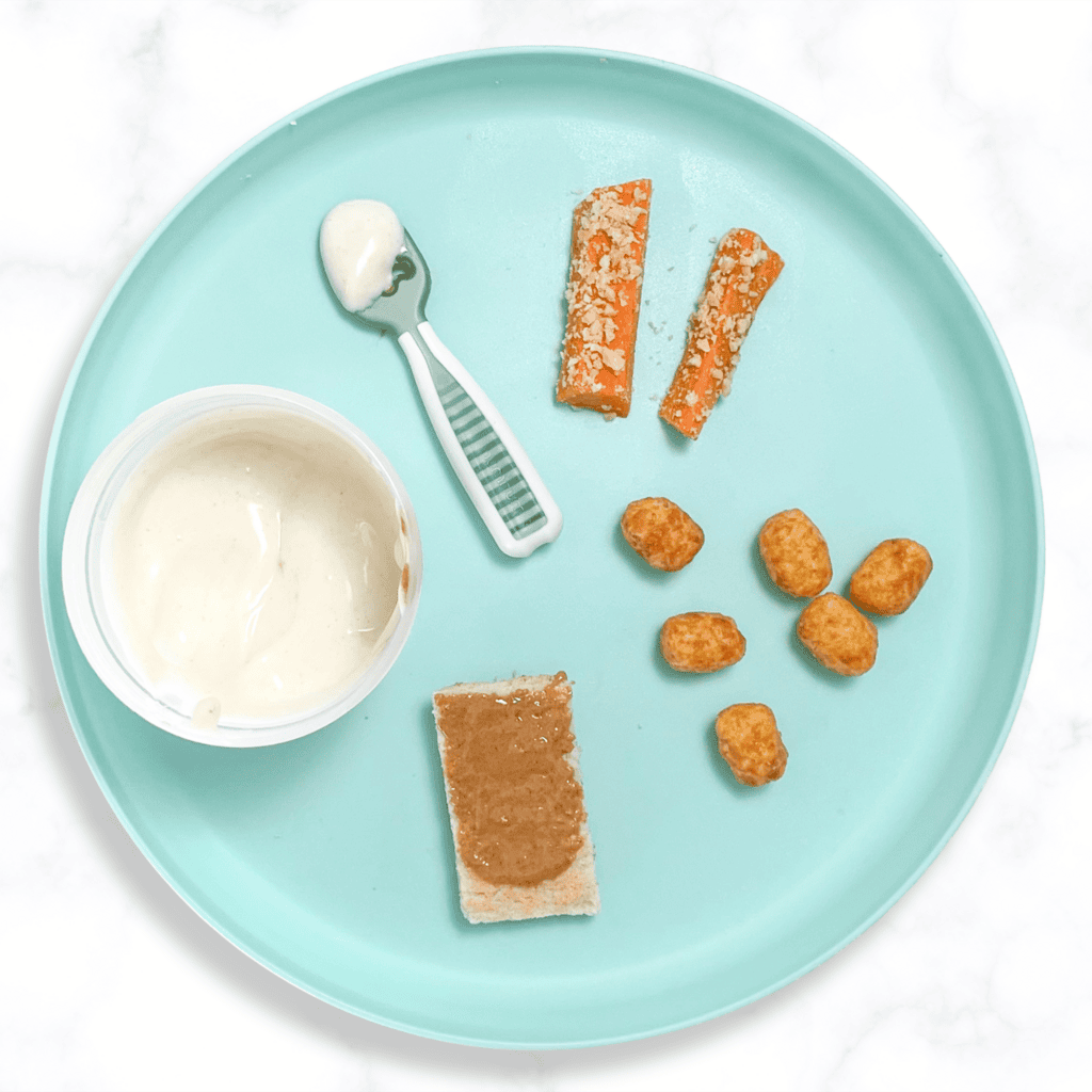 Teal baby plate on a white marble kitchen counter showing different ways to serve peanuts to your 6-12 month your old.