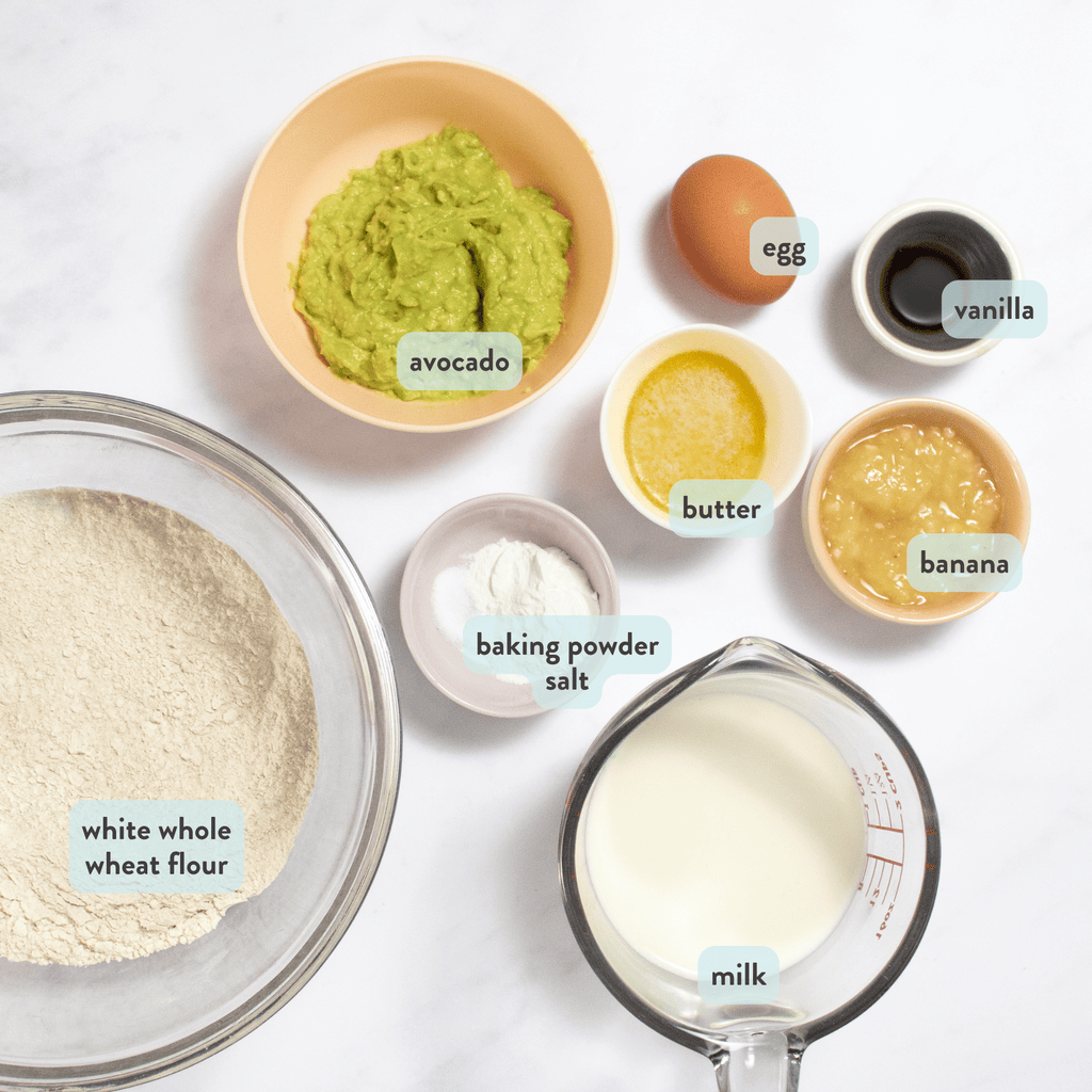 ingredients for avocado pancakes on my kitchen counter - white whole wheat flour, milk, banana, butter, avocado, egg and vanilla extract.